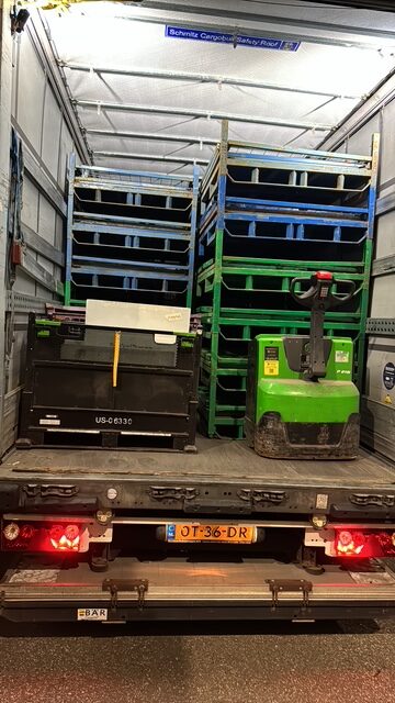 Bijlading en opvullingen Geladen laadruimte met pallets en een elektrische palletwagen