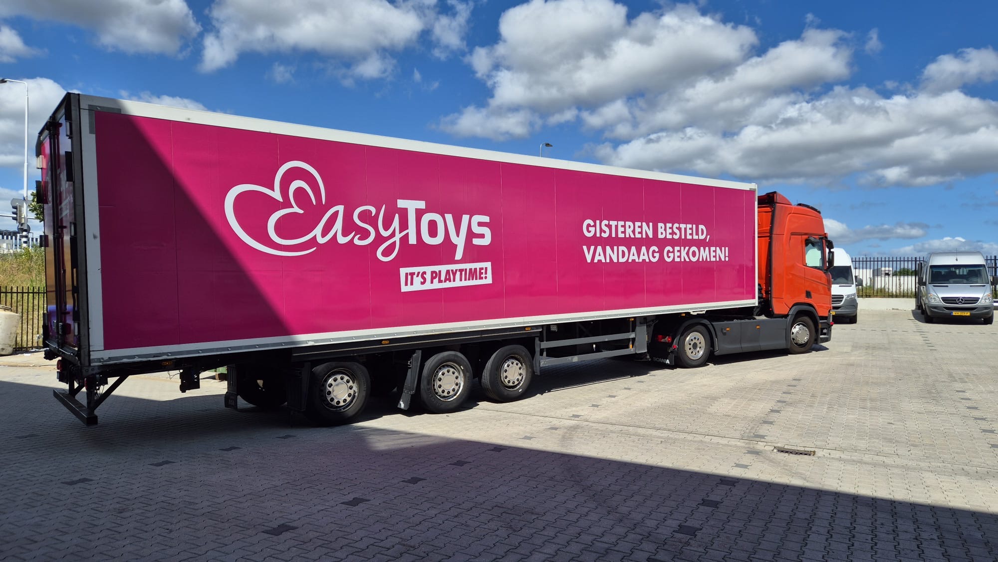 Scania met roze koeloplegger op een zonnig terrein